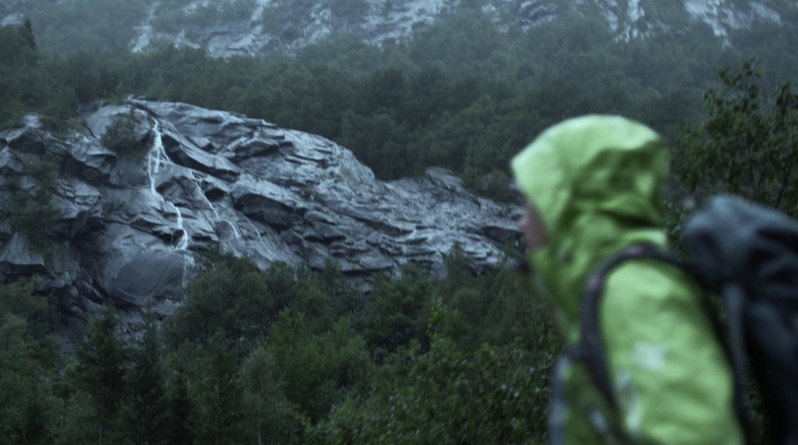 a person with a backpack is looking at a mountain