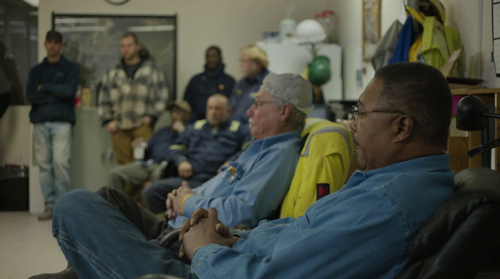 a group of men sitting in chairs in a room