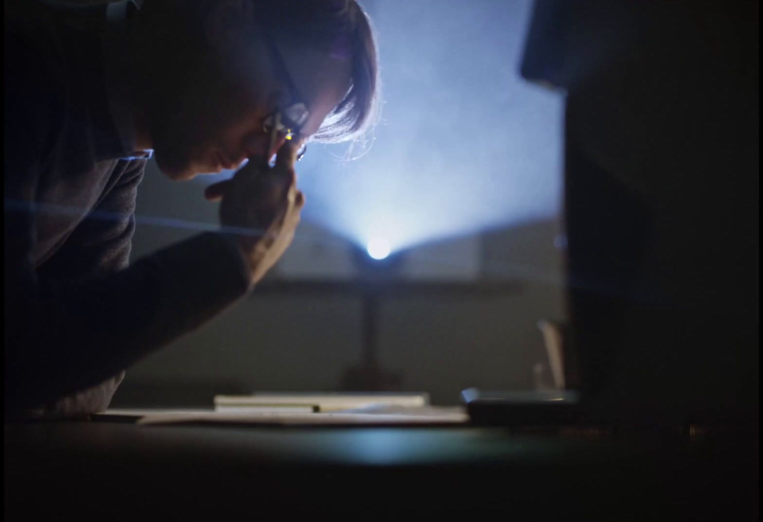 a person sitting at a desk in front of a laptop computer