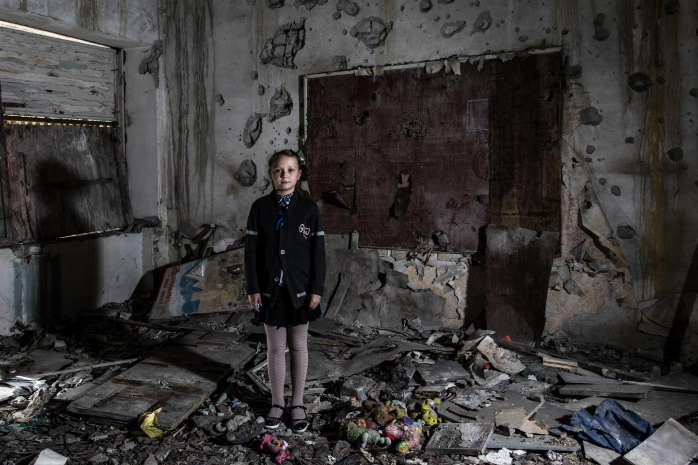 a woman standing in a room full of debris