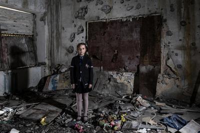 a woman standing in a room full of debris