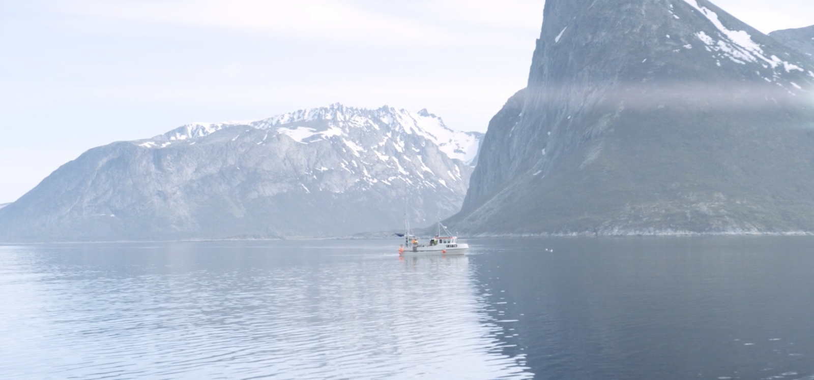 a boat in a body of water with mountains in the background