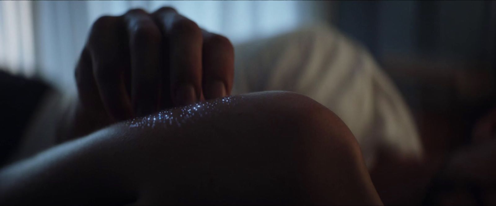 a blurry image of a woman's hands resting on her chest