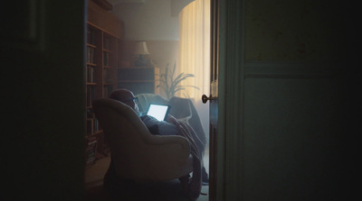 a man sitting in a chair using a laptop computer