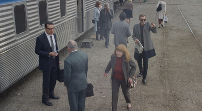 a group of people standing next to a train