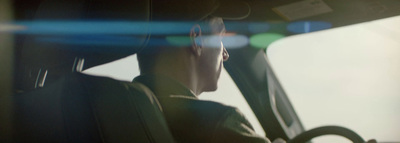 a man sitting in a car looking out the window