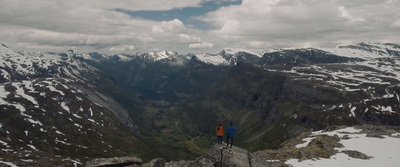 a person standing on top of a mountain in norway