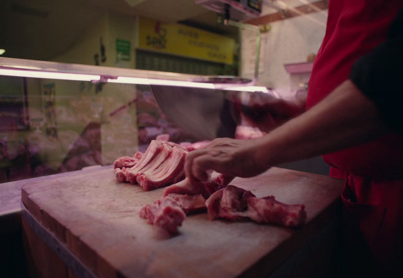 a person cutting up meat on a cutting board