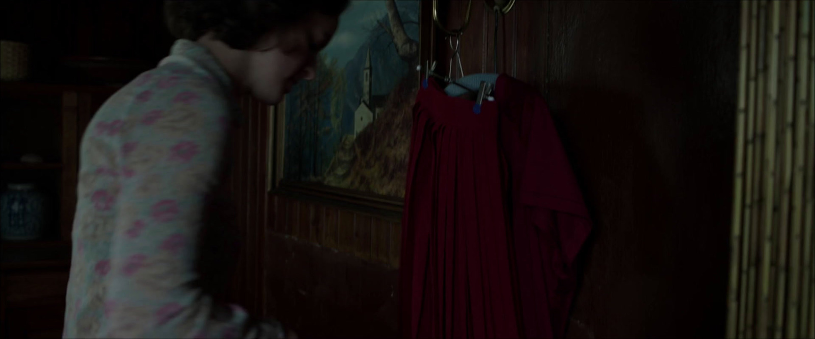 a woman standing in a room next to a red curtain