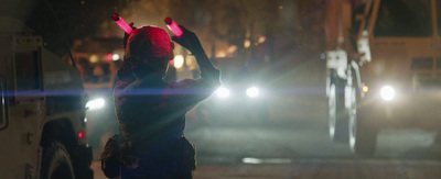 a person standing in the street with their arms in the air