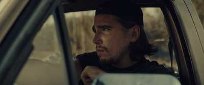 a man sitting in a car looking out the window