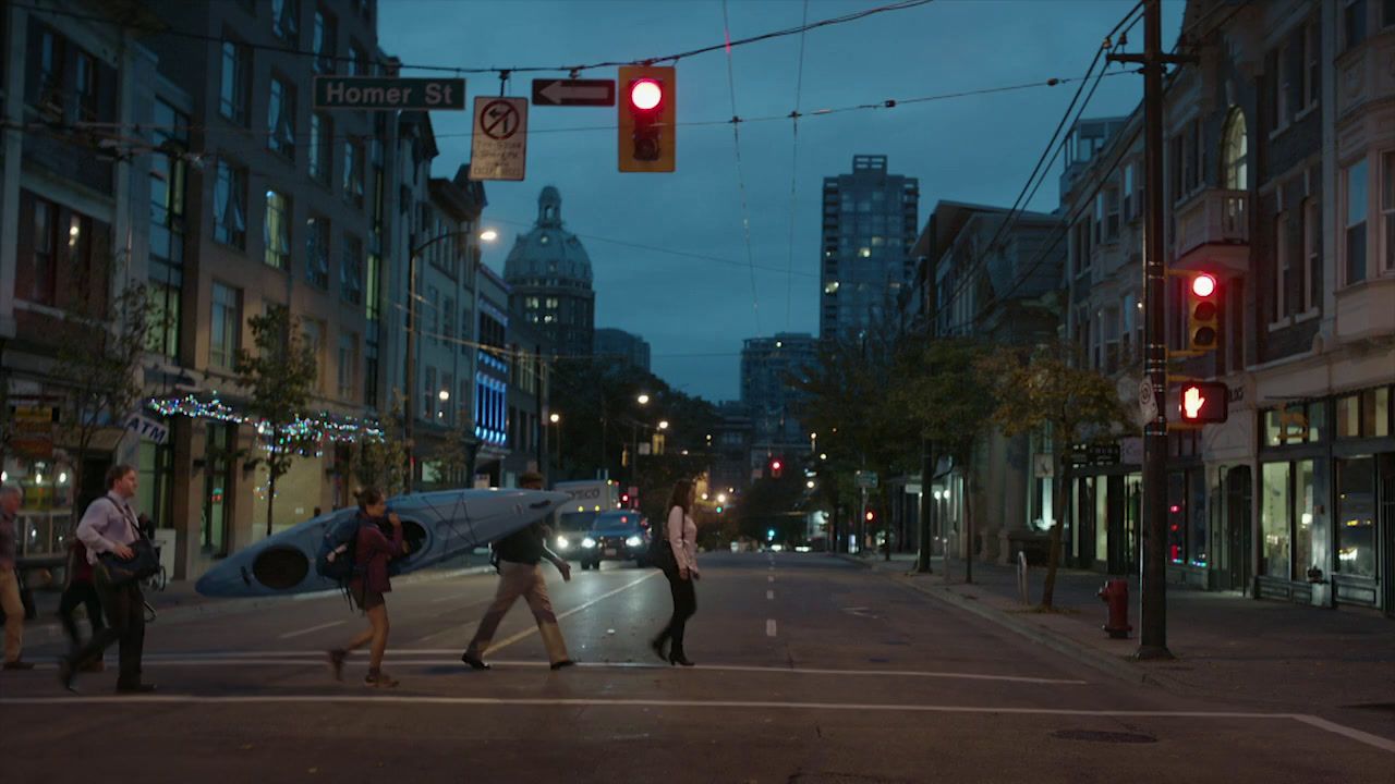 a group of people crossing a street at night