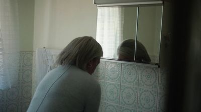 a woman standing in front of a bathroom mirror