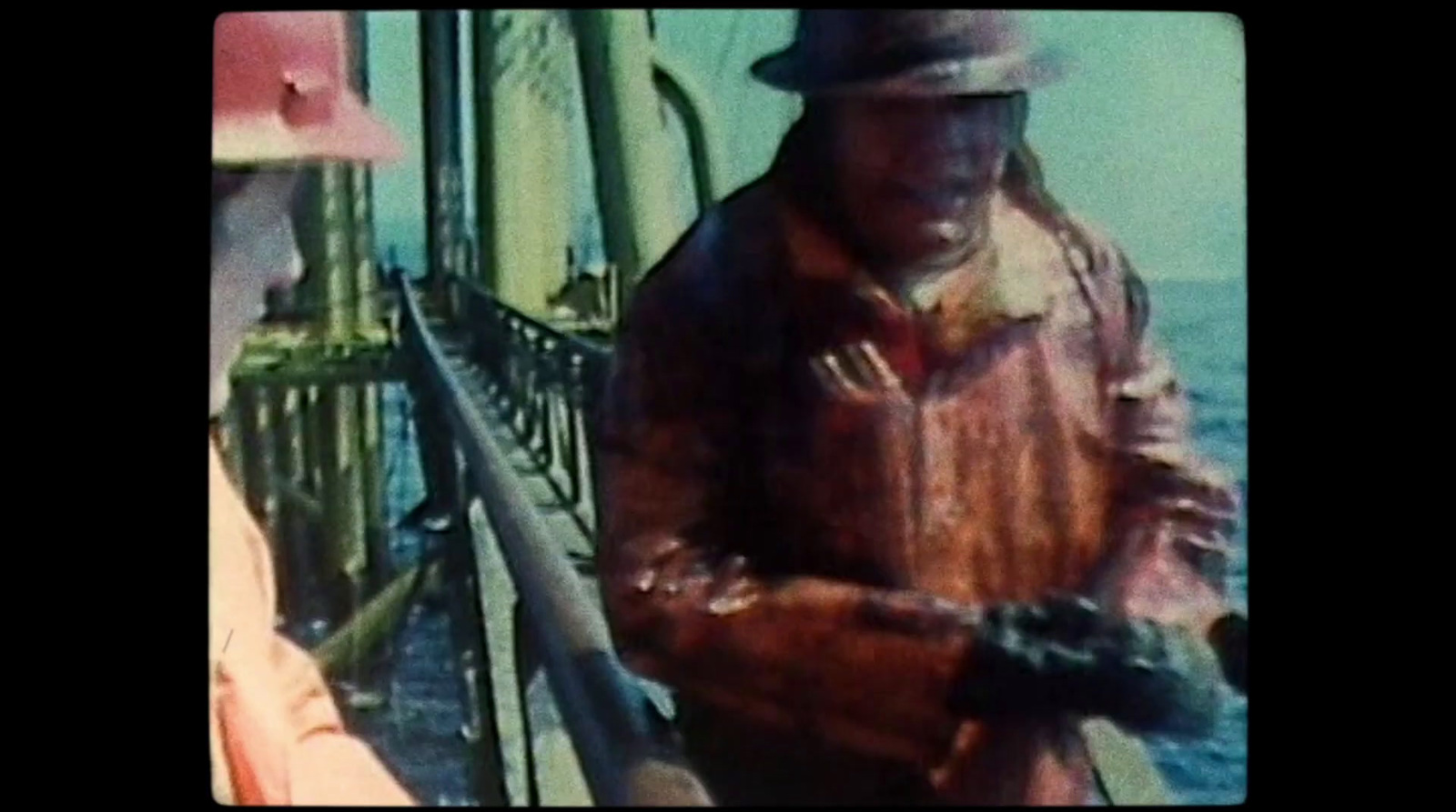 a man standing next to a boat holding a fishing pole