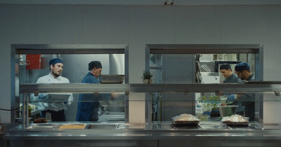 a group of chefs in a kitchen preparing food