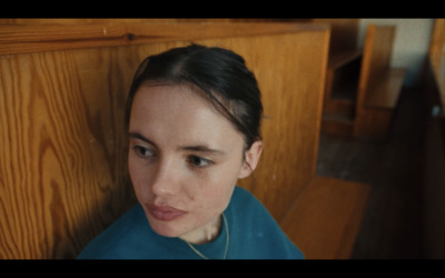 a woman sitting on a bench looking at the camera