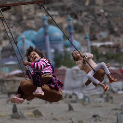 a young girl swinging on a swing set