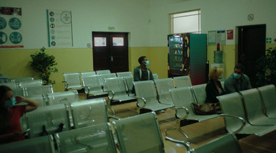 a group of people standing around a room filled with chairs