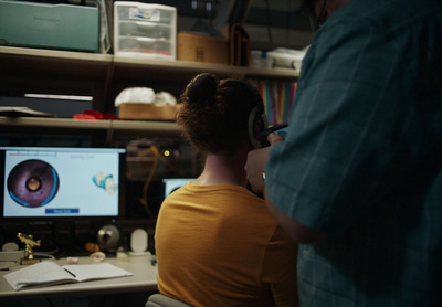 a man and a woman sitting in front of a computer monitor