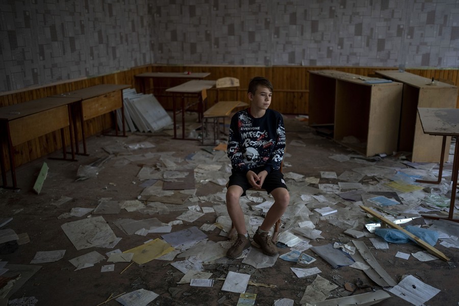 a young boy sitting on a pile of papers