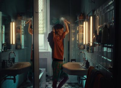 a man standing in a bathroom next to a sink