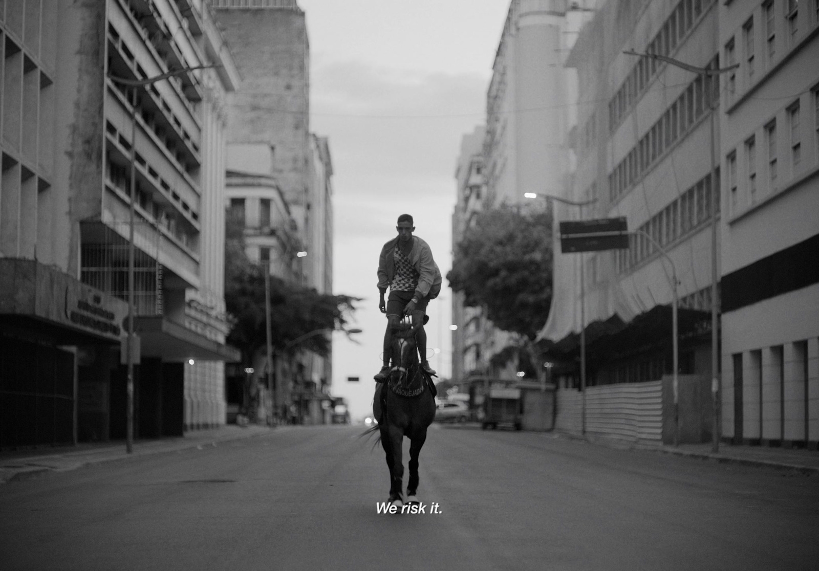 a man riding on the back of a horse down a street