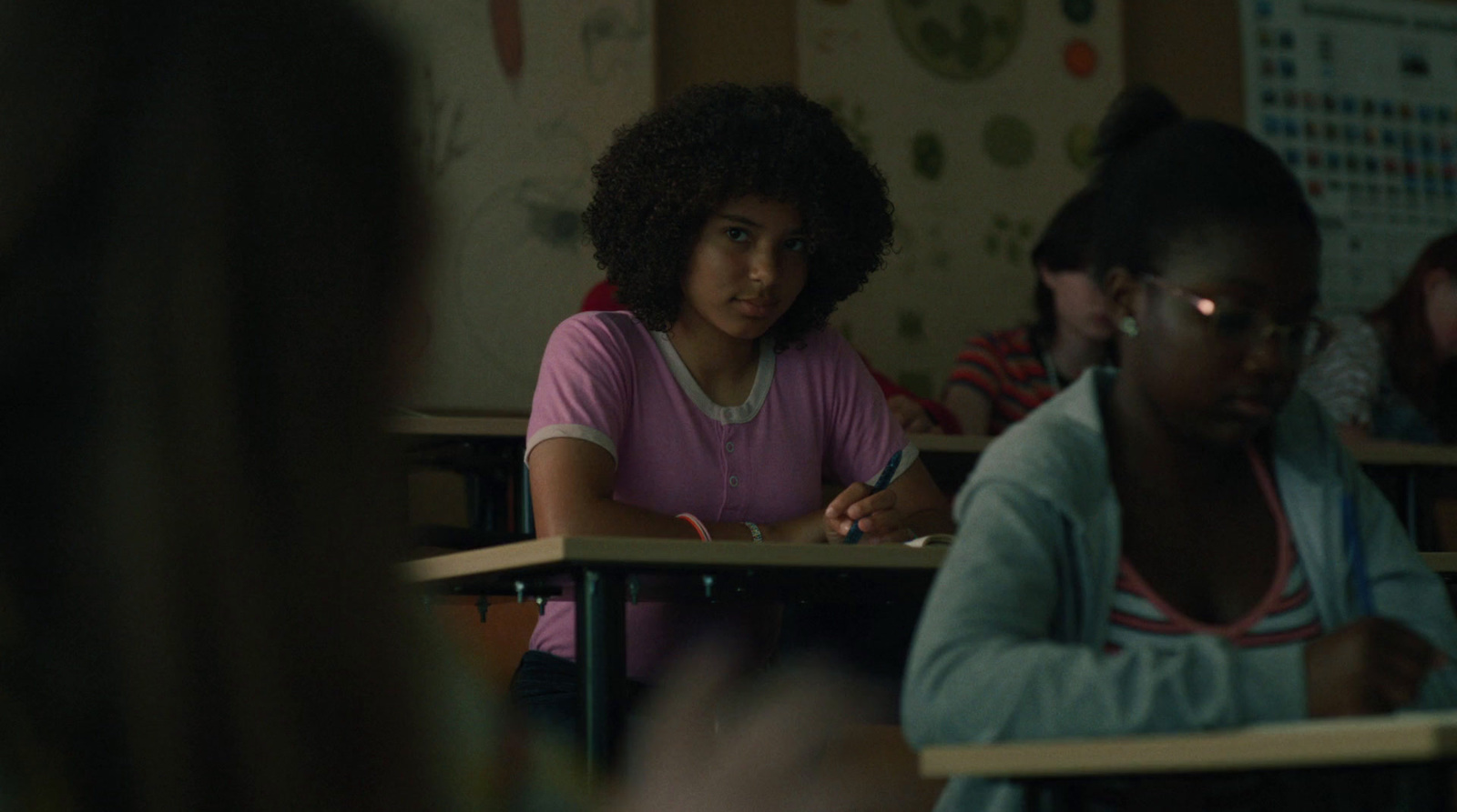 a group of girls sitting at desks in a classroom