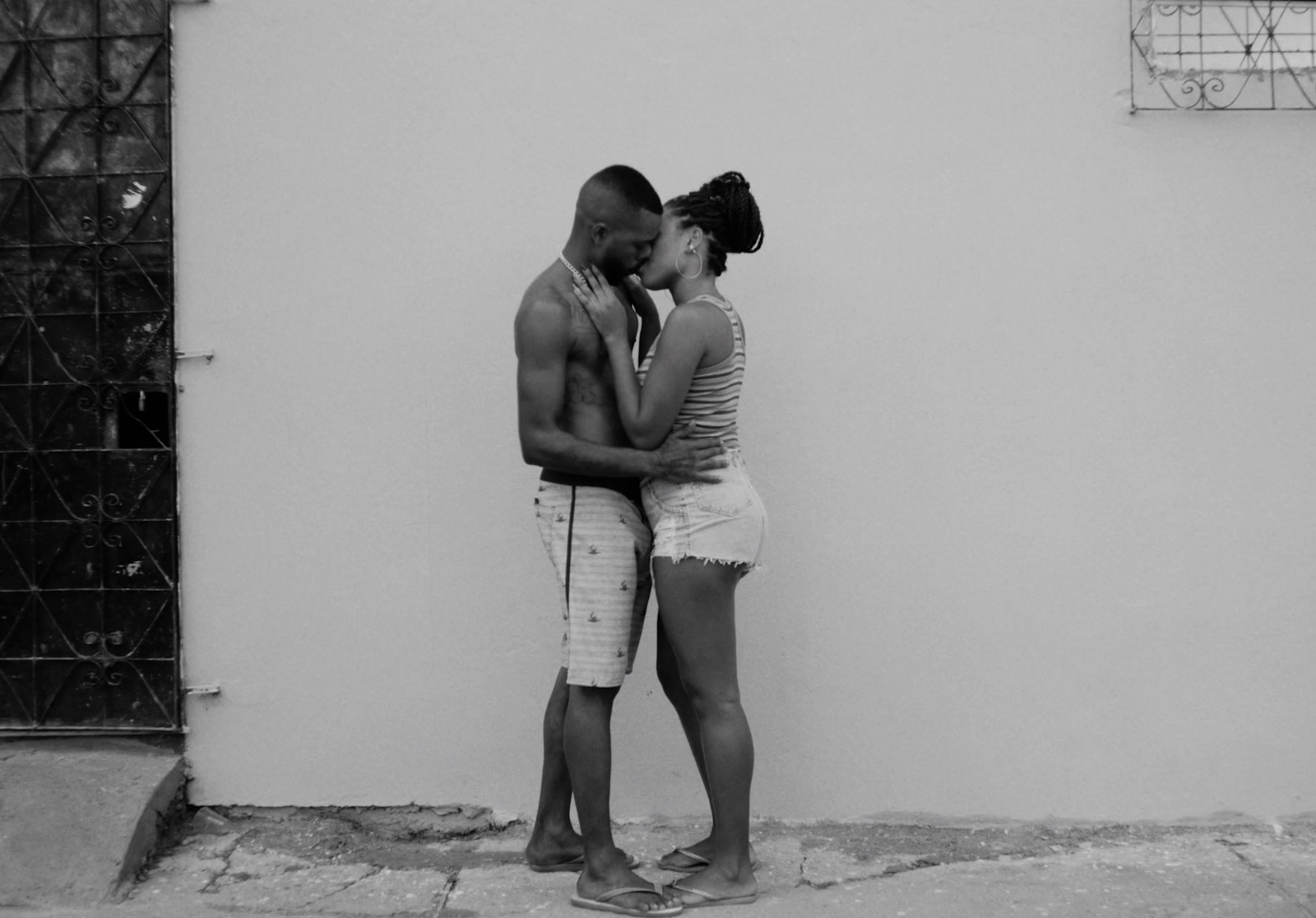 a black and white photo of a man and a woman kissing