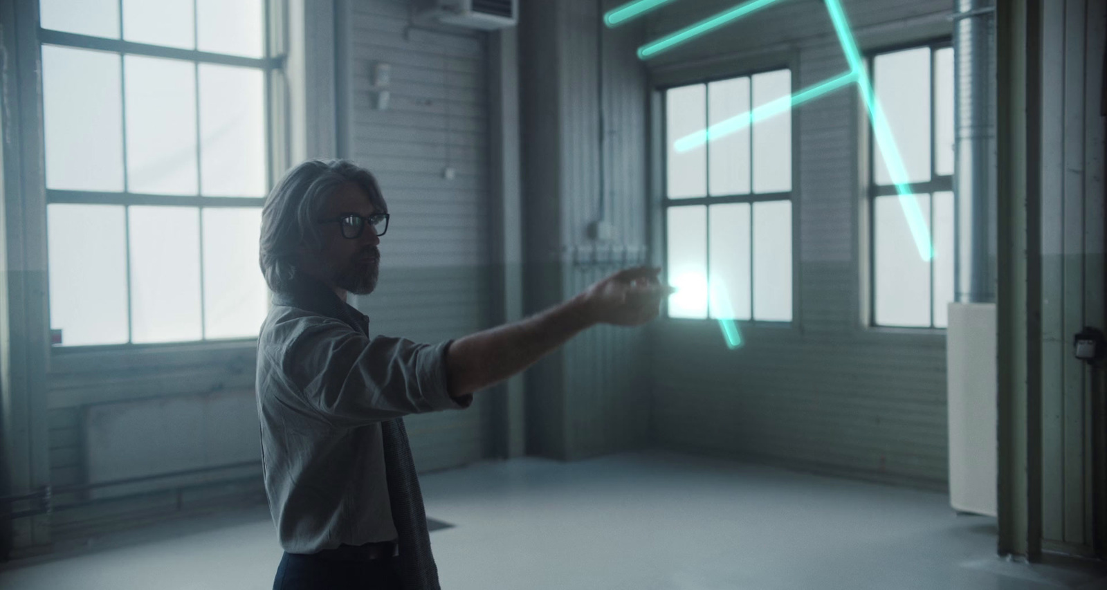 a man standing in an empty room pointing at something