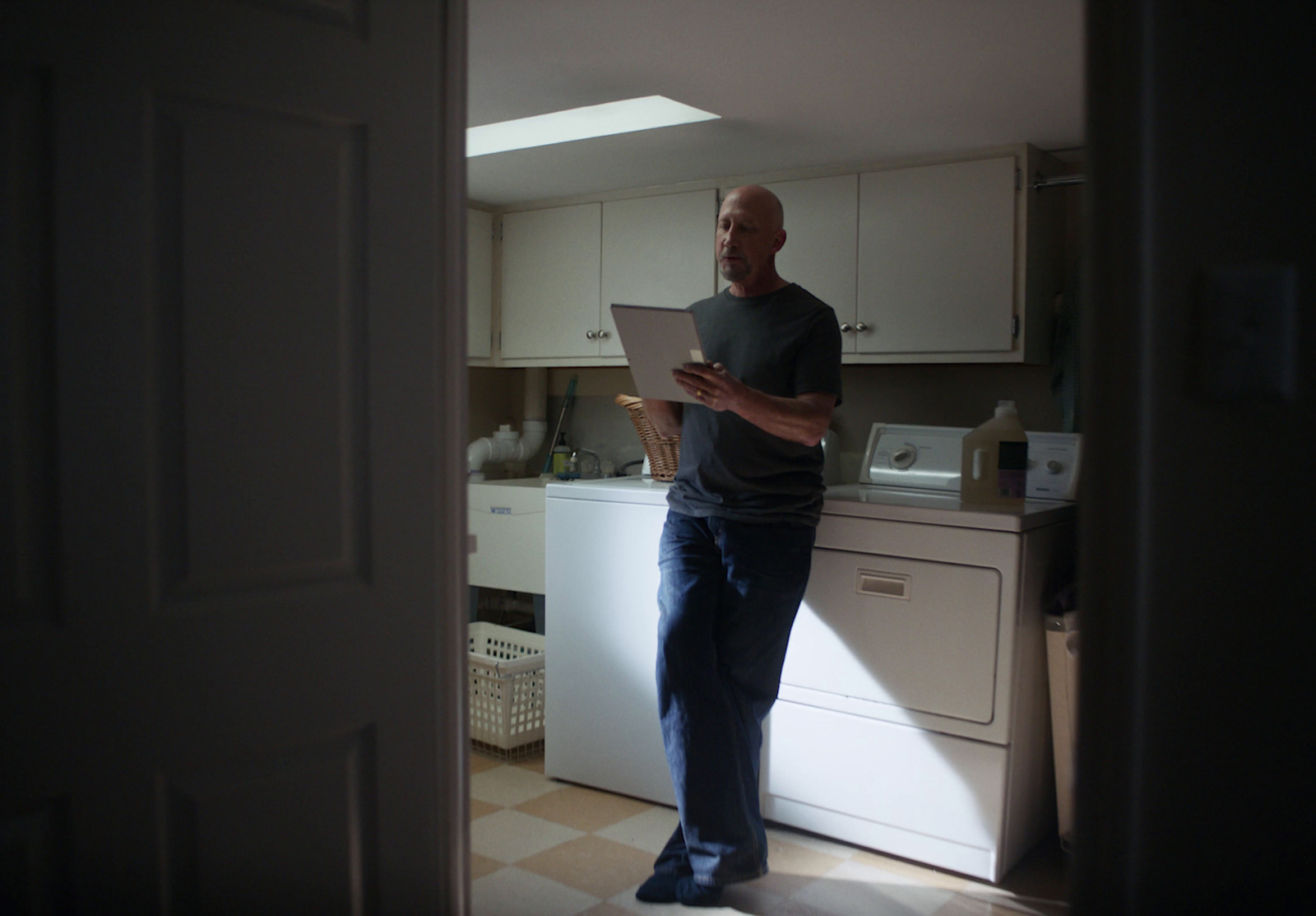 a man standing in a kitchen looking at a piece of paper