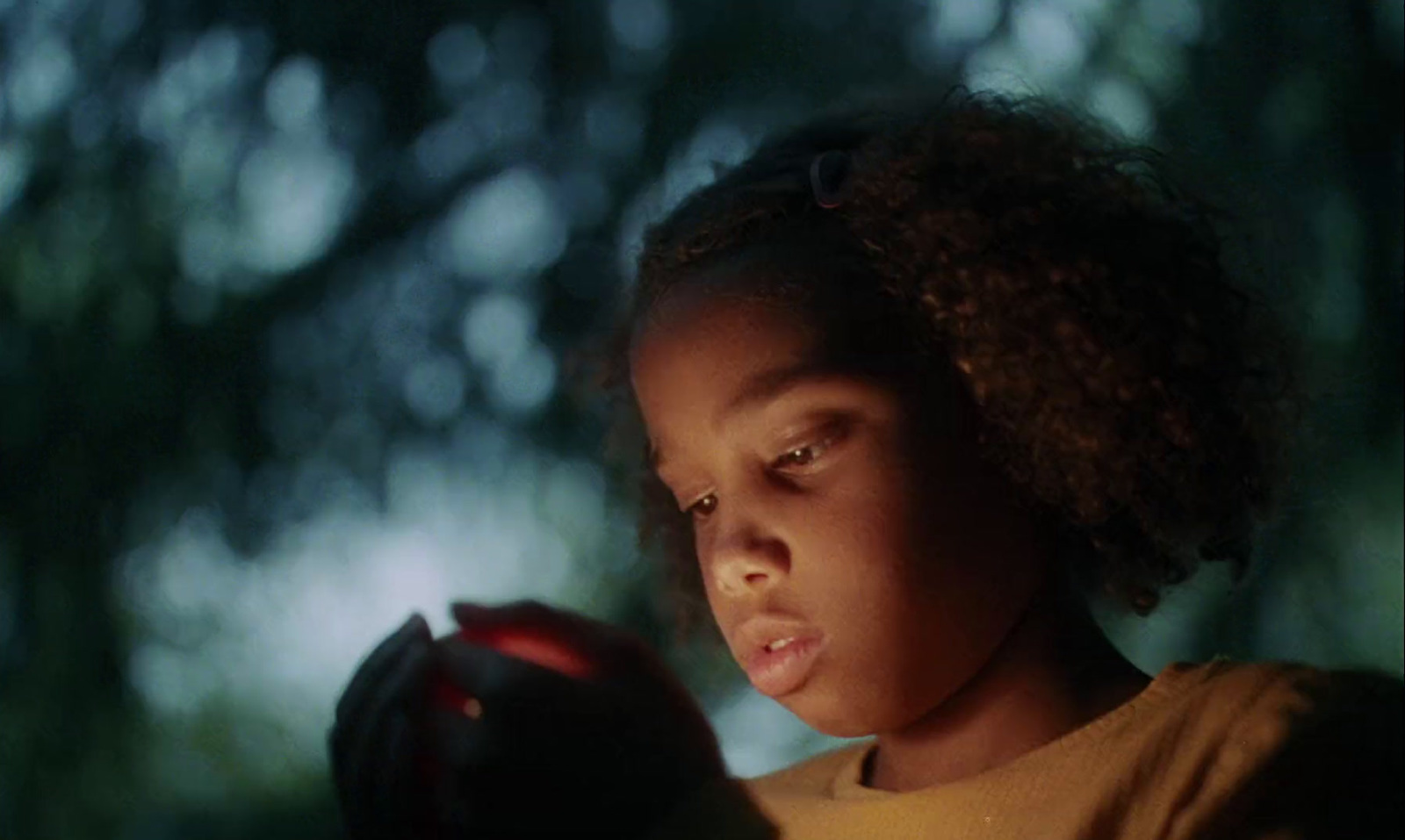 a young girl holding a red object in her hands