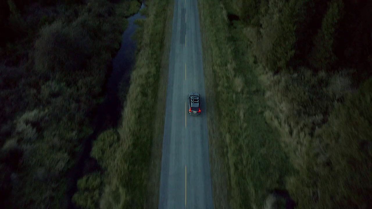 an aerial view of a car driving down a road