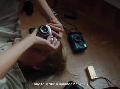 a woman laying on the floor holding a camera