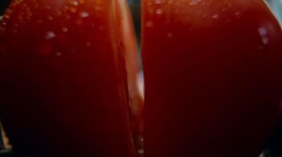 a close up of a tomato with water droplets on it