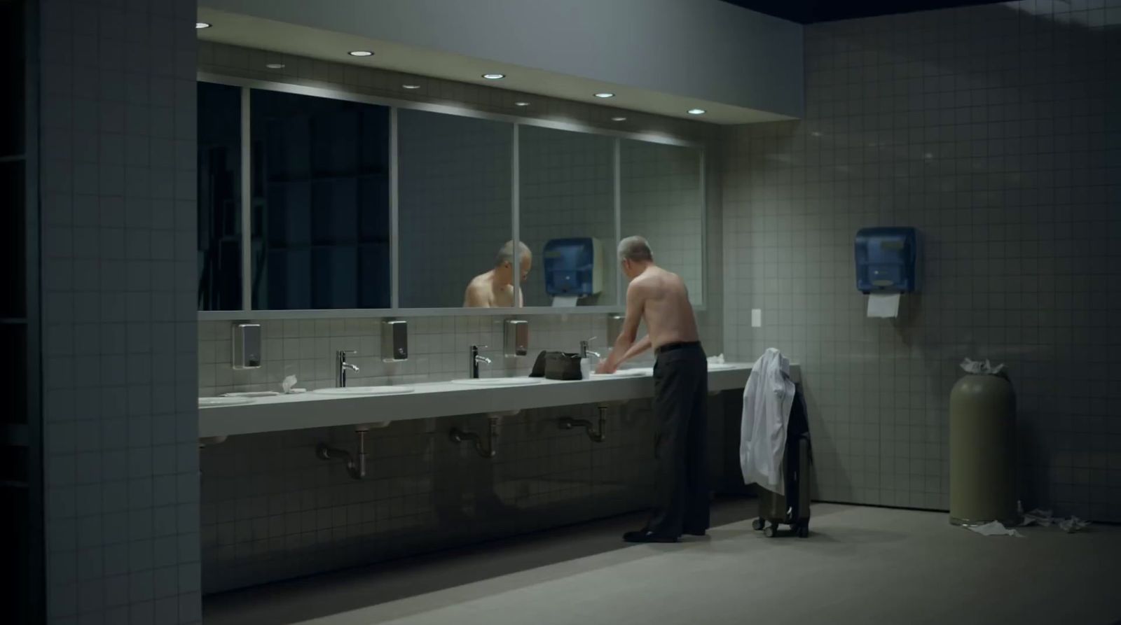 a man standing in front of a sink in a bathroom