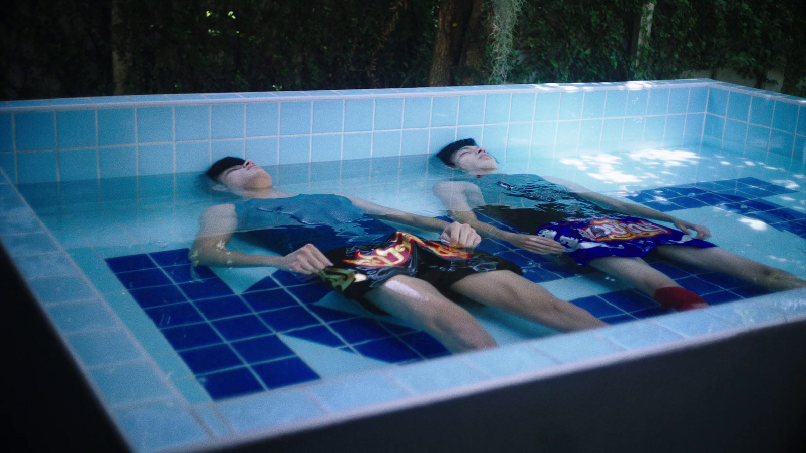 a couple of people that are laying down in a pool