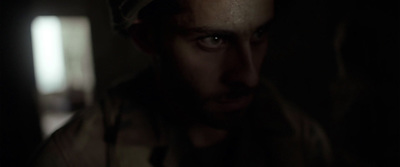 a man in a dark room looking at the camera