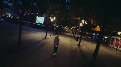 a man riding a skateboard down a street at night