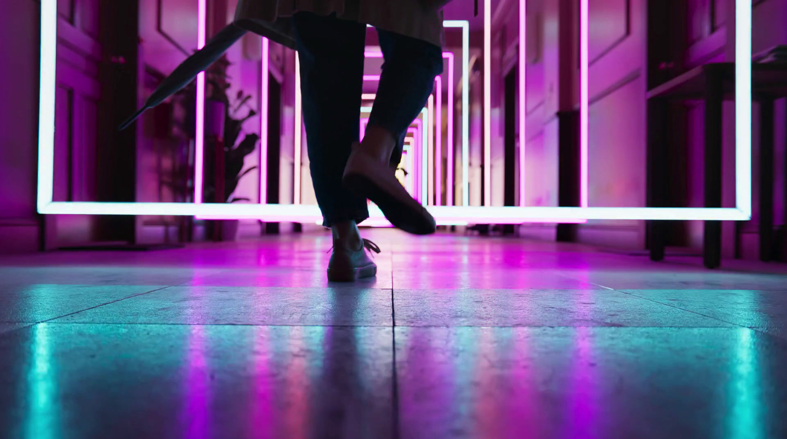 a person walking on a tiled floor in front of a mirror