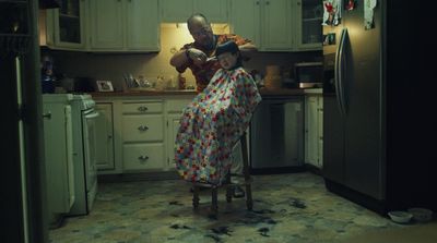 a man in a kitchen with a child on a chair