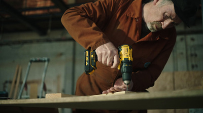 a man using a drill to drill a piece of wood