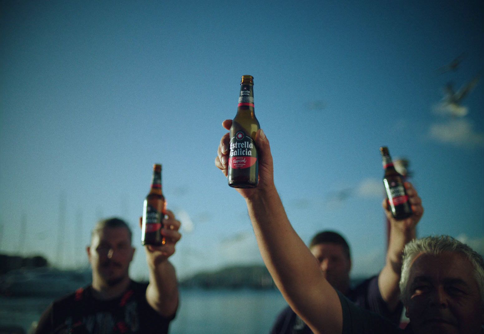 a group of people holding up beer bottles