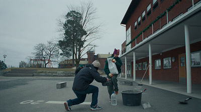 a man picking up trash in front of a building