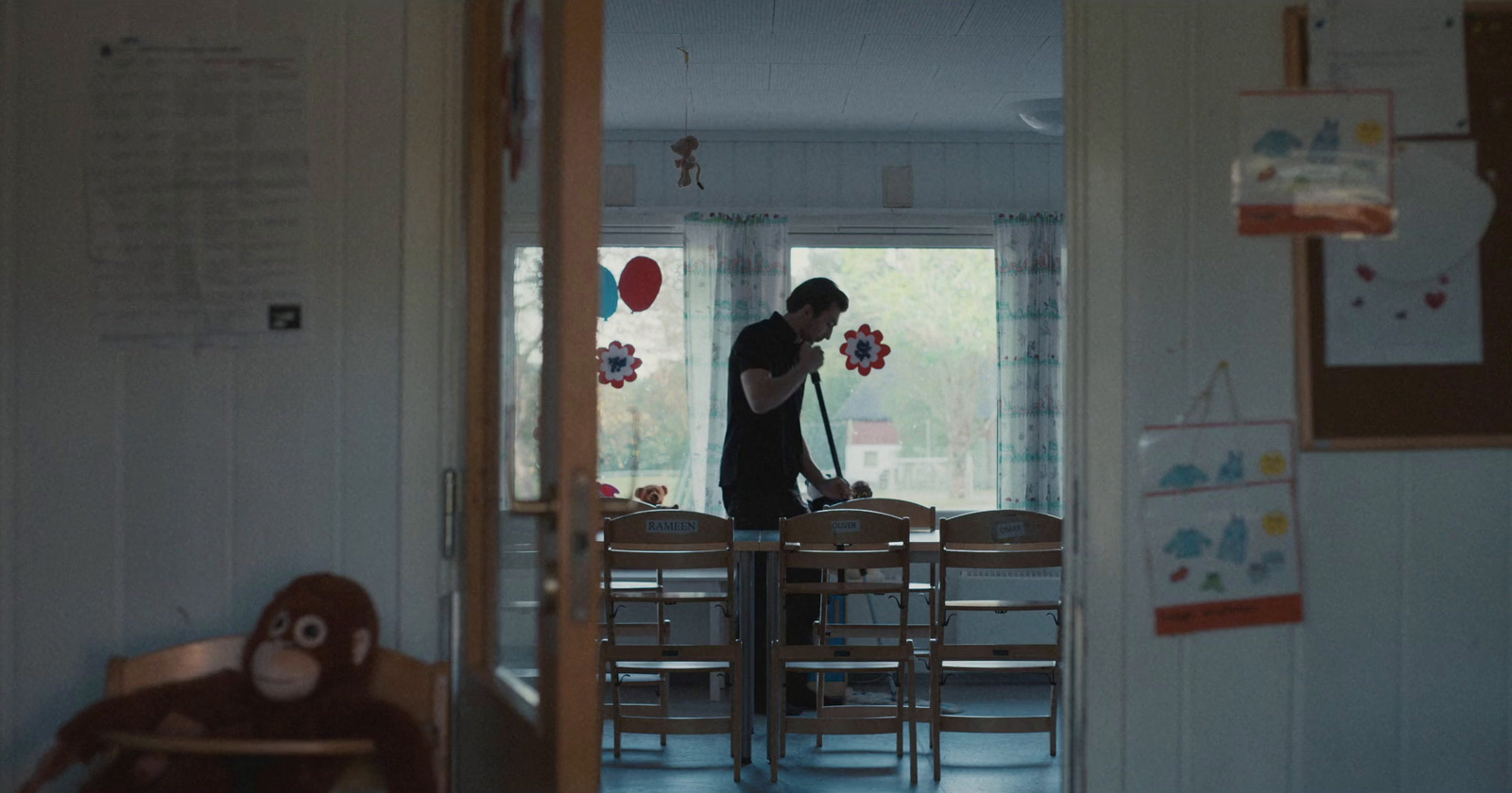 a woman standing in a room with a teddy bear