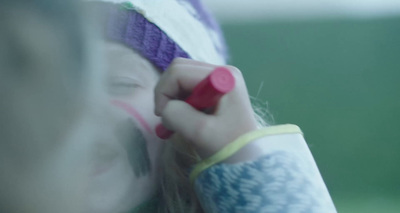 a little girl holding a pink object in her hand