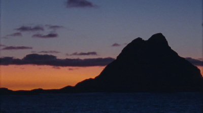 a large mountain in the middle of a body of water