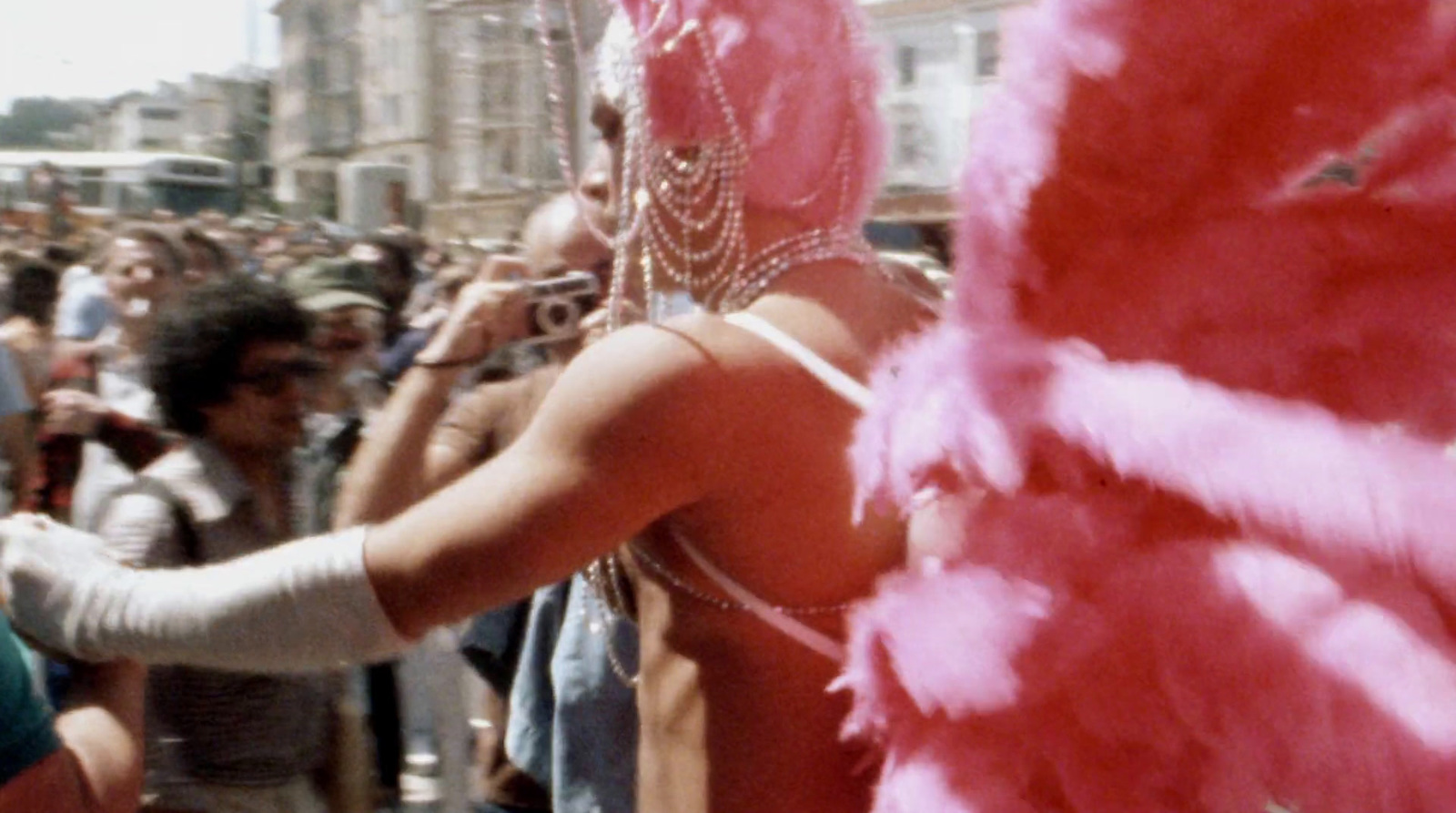 a woman in a pink feathered costume is talking on a cell phone