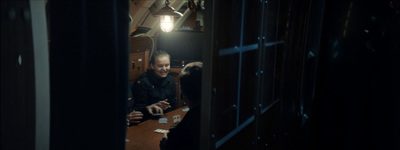 a man sitting at a table in a dark room