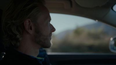 a man sitting in a car looking out the window