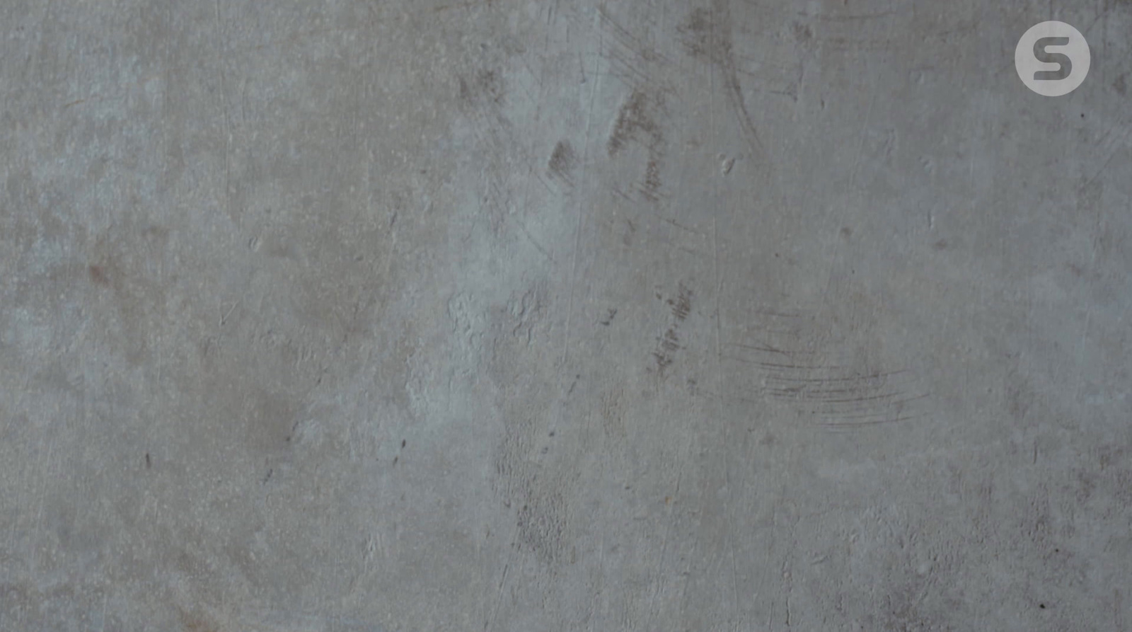 a man riding a skateboard on top of a cement floor